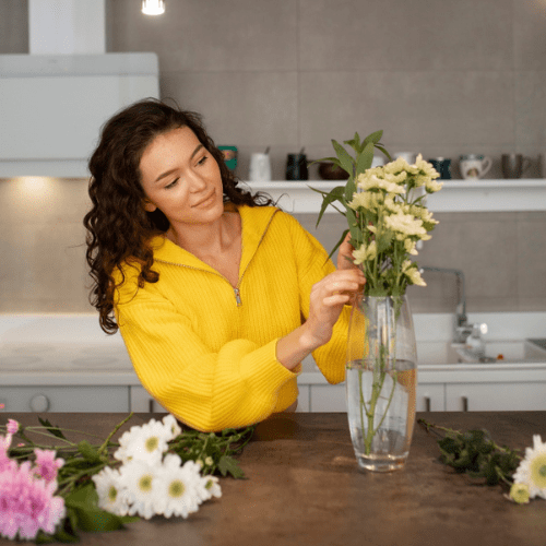 A woman putting flowers in a vase